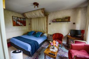 Brissac-QuincéにあるHôtel Le Castelのベッド、机、テレビのある寝室