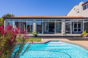 a house with a swimming pool in front of a house at Flensborg Studios & Penthouse - Langebaan Golf Estate in Langebaan
