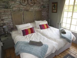 a bedroom with a large bed with towels on it at Dandelion Cottage in Boschkop