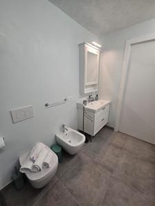 een witte badkamer met een wastafel en een toilet bij pontile 2 in Paratico +32 foto's