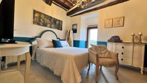a bedroom with a bed and a dresser and a chair at Residenza Teatro Antico in Todi