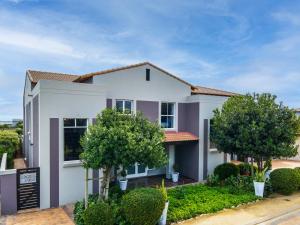 a white house with trees in front of it at Flensborg Studios & Penthouse - Langebaan Golf Estate in Langebaan