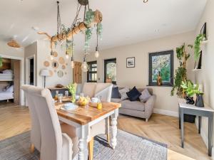 a dining room and living room with a table at Bwythyn Cudd in Manortown