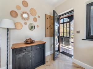 a kitchen with a black cabinet and a sliding glass door at Bwythyn Cudd in Manortown