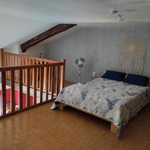 - une chambre avec un lit doté d'oreillers bleus et un escalier dans l'établissement La Vallée De La Loire, à Solignac-sur-Loire