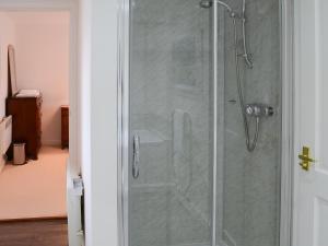 une cabine de douche avec une porte de douche en verre dans l'établissement The Cottage, à Rispond