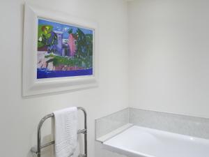 une salle de bain avec un tableau sur le mur à côté d'un lavabo dans l'établissement The Cottage, à Rispond 5 autres photos