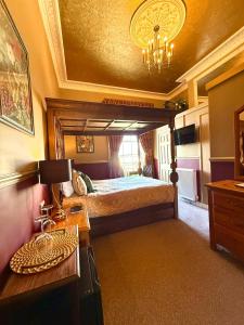 a bedroom with a bed and a table with a lamp at The Angove - Adults Only in Weymouth