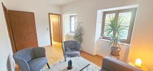 Una sala de estar con dos sillas y una mesa. en Loft Klagenfurt, en Klagenfurt