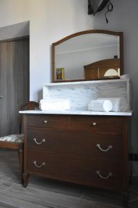 a bedroom with a wooden dresser with a mirror at La Pergola in Postalesio