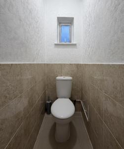 aseo blanco en un baño con ventana en East Ham House, en Londres 6 fotos más