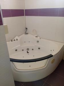 una bañera blanca en un baño con morado en Chambre Deluxe New, en Thiès