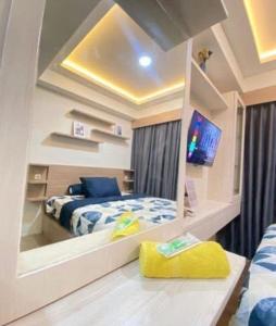 a bedroom with a bed and a tv in a mirror at RD Property in Bandung
