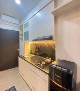 a small kitchen with a stove and a microwave at RD Property in Bandung