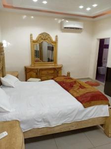 Un dormitorio con una cama grande y un espejo. en Chambre Deluxe New, en Thiès