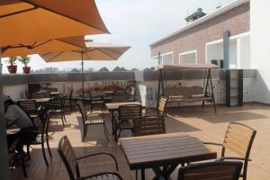 an outdoor patio with tables and chairs and umbrellas at Grabbo Luxury Apartments in Gwarinpa