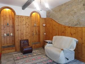 een woonkamer met houten wanden en een stoel bij Detached cottage in town, Spacious rustic charm in Lindley