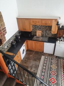 een kleine keuken met een spoelbak en een fornuis bij Detached cottage in town, Spacious rustic charm in Lindley