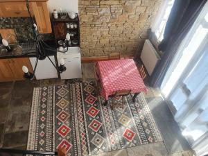 een uitzicht op een tafel en stoelen op een tapijt bij Detached cottage in town, Spacious rustic charm in Lindley