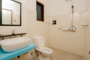 a white bathroom with a sink and a toilet at Horizon Palace - Kabalana in Ahangama