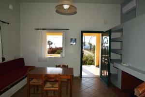 a living room with a table and chairs and a door at Βιλλα Βεατρικη/ villa Beatrice in Potokáki
