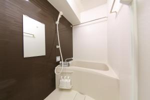a white bathroom with a sink and a mirror at Tokyo Time Traveler 駅徒歩5分 暮らすように泊まれるホテル in Tokyo
