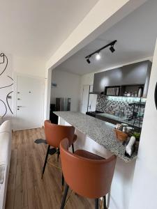 a kitchen with a counter and some orange chairs at Tatu city Springs in Tatu City