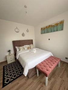 a bedroom with a large bed with a pink bench at Tatu city Springs in Tatu City