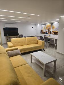 a living room with yellow couches and a table at Nancy zimr 1 in Massada