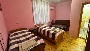 a room with two beds and a couch at Farid HOSTEL in Ganja