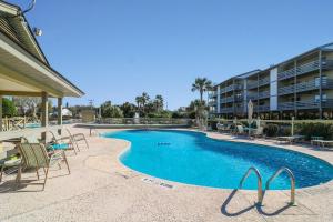 a swimming pool with chairs and a building at 33C Lighthouse Point in Tybee Island