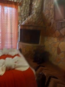 Un dormitorio con una cama y una pared de piedra. en Kalavrita Relax, en Kalavrita