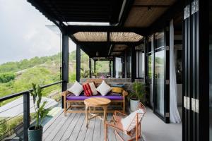 ein Balkon eines Hauses mit einer lila Couch und Stühlen in der Unterkunft Mar de Uluwatu - Ocean View Villa in Uluwatu