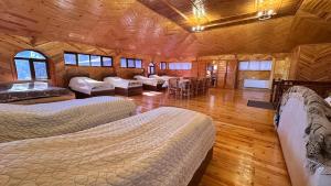 a room with three beds and a couch and a table at Farid HOSTEL in Ganja