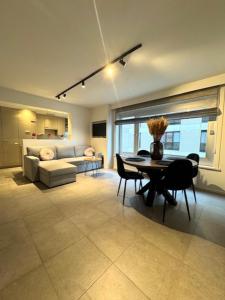 a living room with a table and a couch at Residentie Peter Pan in Knokke-Heist