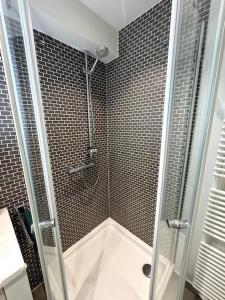 a shower with a glass door in a bathroom at Residentie Peter Pan in Knokke-Heist