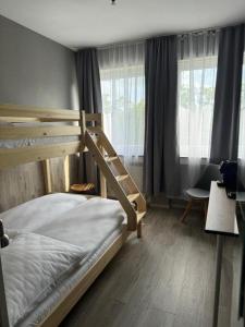 a bedroom with a bunk bed and a chair at SkyLine Hotel Hannover in Hannover