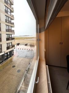 a large window in a room with a view of a building at Residentie Peter Pan in Knokke-Heist