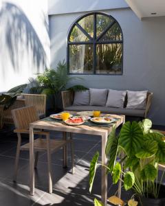 a patio with a table and chairs and a couch at Kirulhiya Omadhoo - Live the Island Dream in Omadhoo