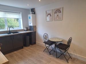 a kitchen with a table and chairs and a sink at Coach house in Llantwit Fardre +2 photos