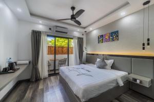a bedroom with a bed and a window at Kirulhiya Omadhoo - Live the Island Dream in Omadhoo