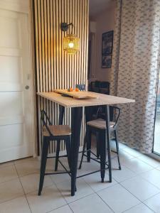 a dining table with two chairs and a light fixture at Corsappart in Porto-Vecchio