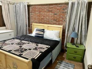 a bedroom with a bed and a brick wall at Teonil in Jarabacoa +18 photos