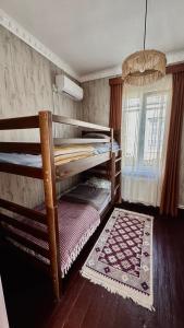 a bedroom with two bunk beds and a rug at Megruli House in Poti +16 photos