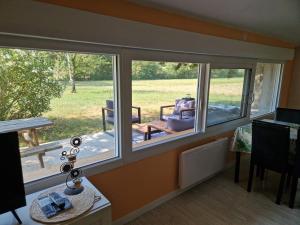 a room with two windows with a view of a yard at Cottage with large garden in Rieumajou