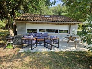 a patio with a table and chairs and a grill at Cottage with large garden in Rieumajou
