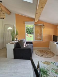 a living room with a couch and a window at Cottage with large garden in Rieumajou