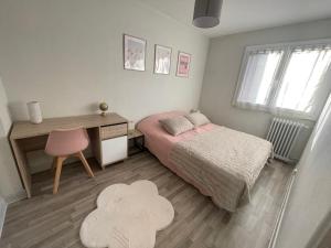 a bedroom with a bed and a desk and a chair at Appartement à 2 pas du centre, 2 chambres, parking in Aurillac