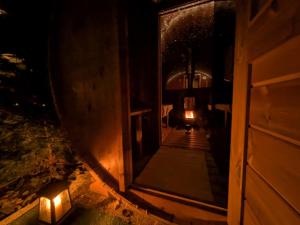 an open door of a building at night with lights at Apartments Giovannini in Fai della Paganella +40 photos