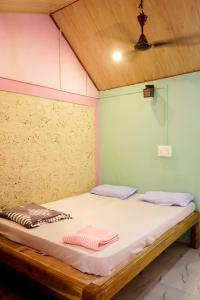 Myna beach stay في جوكارنا: سرير في غرفة عليها منشفتين